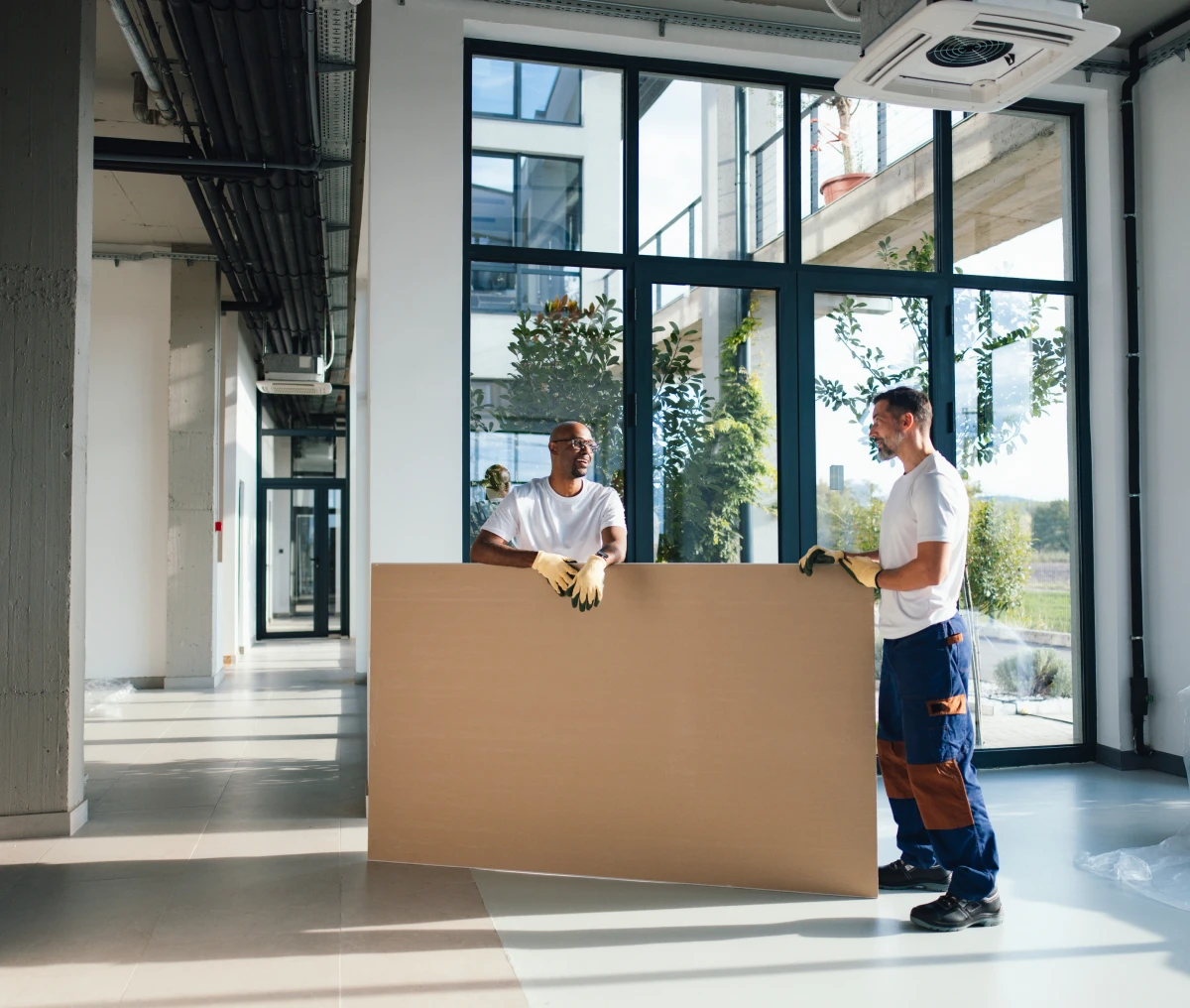 Workers carrying large board in office